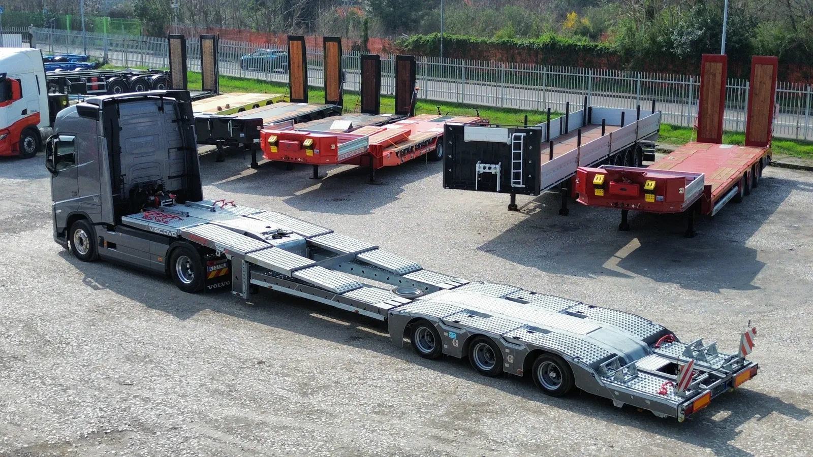 JX-3 PLUS con trattore stradale Semirimorchio carrellone 3 assi allungabile JX-3 PLUS Trailix agganciato al trattore stradale nel piazzale