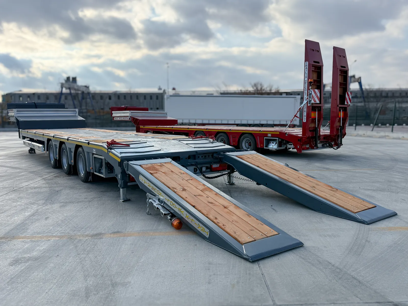 TX-3 SMART grigio rampe abbassate Semirimorchio carrellone 3 assi TX-3 SMART Trailix per trasporto macchine operatrici in versione grigia con rampe abbassate, vista tre quarti