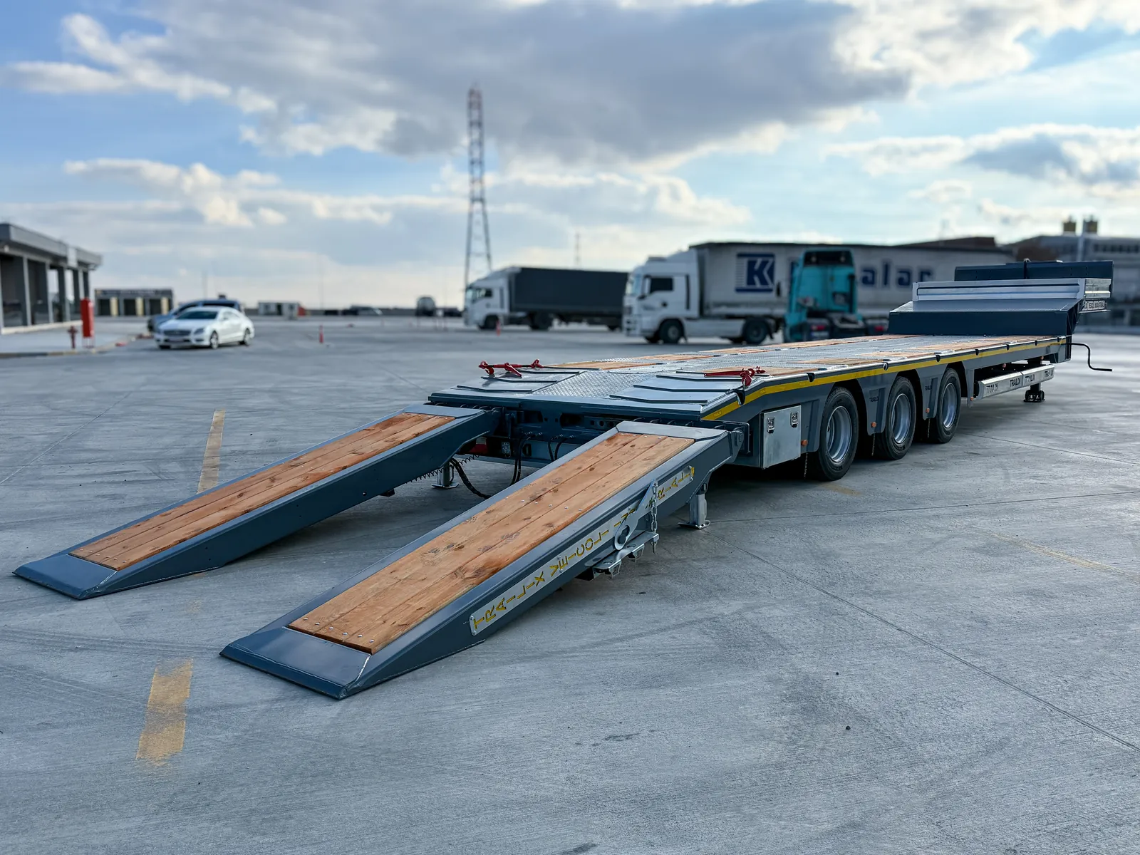 TX-3 SMART grigio vista laterale Semirimorchio carrellone 3 assi TX-3 SMART Trailix per trasporto macchine operatrici in versione grigia, vista laterale con rampe abbassate